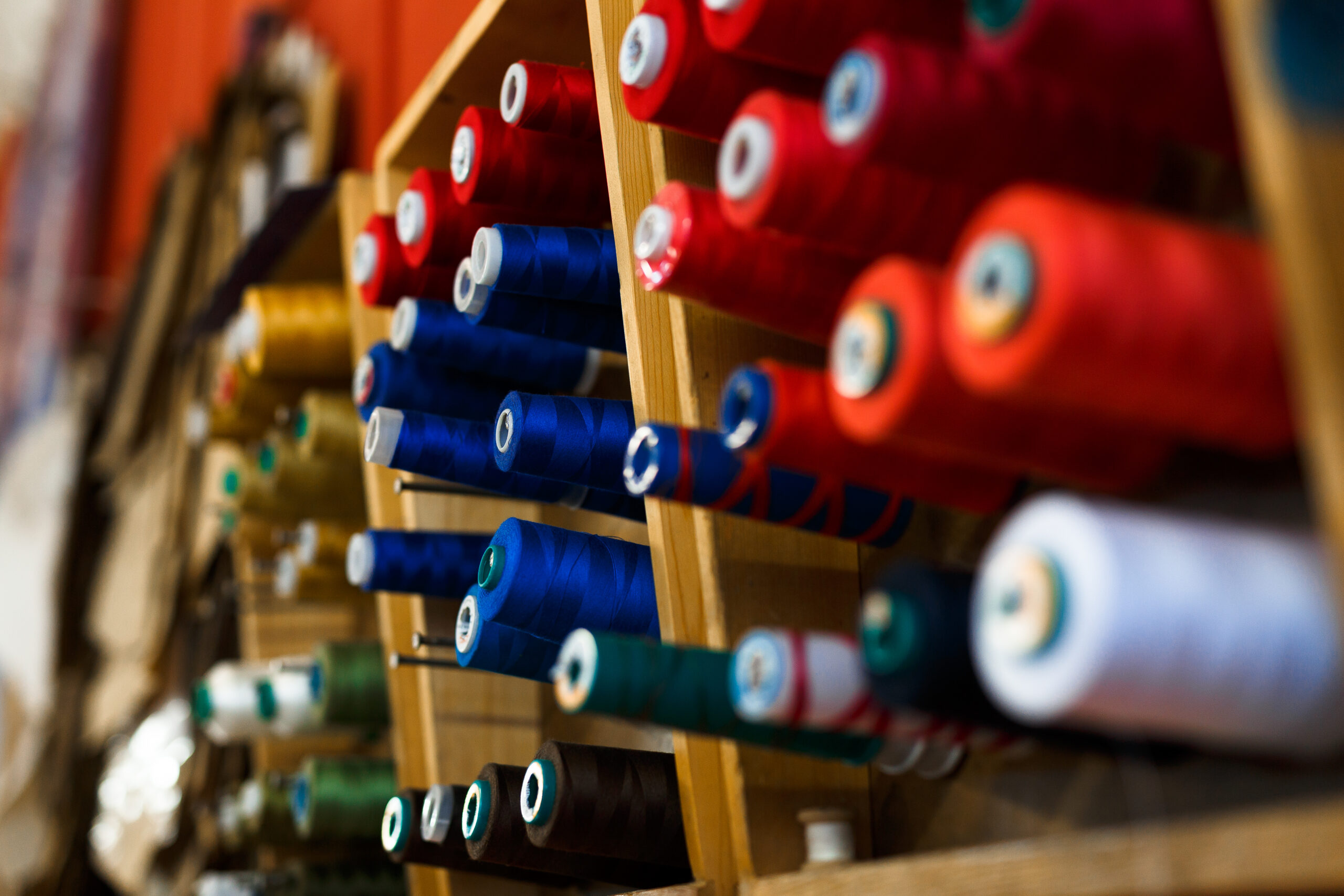 Set of multi-colored spools in workshop of tailor